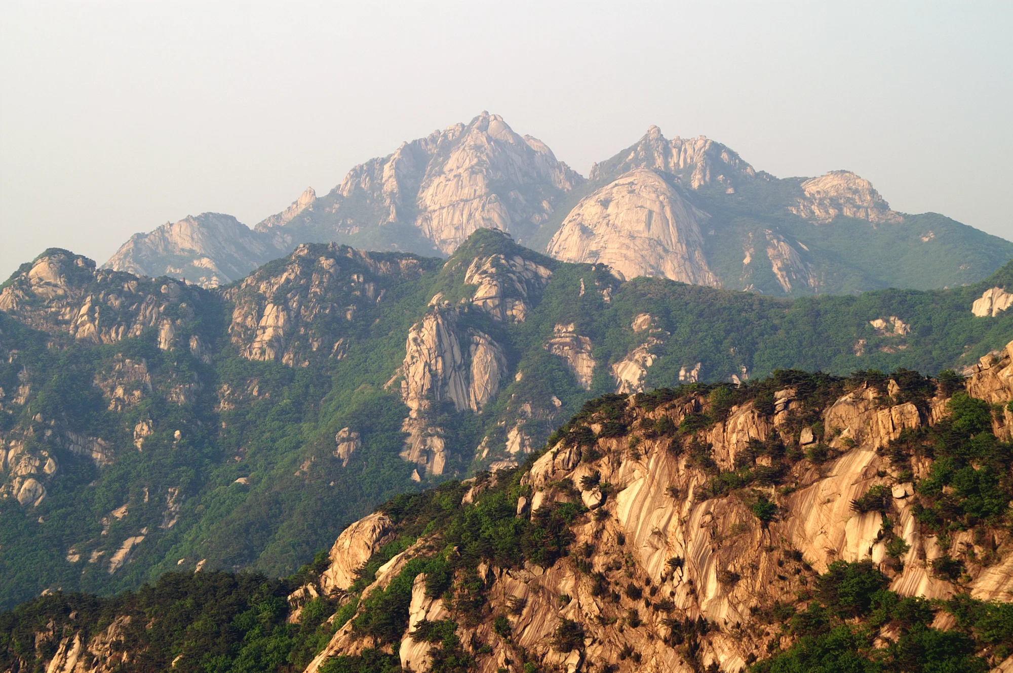 Warm sunlight on the granite peaks and forested ridges of Bukhansan